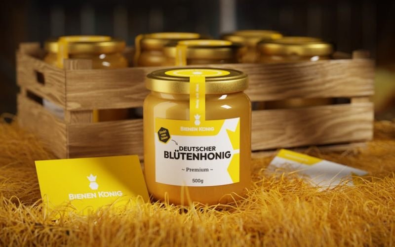 A jar of honey with dipstick set on a wooden table outdoors, perfect for healthy eating.